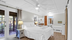 Une chambre à coucher avec un lit, une table de chevet, une lampe et une vue sur l’extérieur.