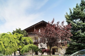 A building with a sloped roof, multiple windows, and a balcony.