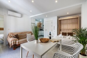 Un salon moderne avec un canapé, une table à manger et une cuisine en arrière-plan.