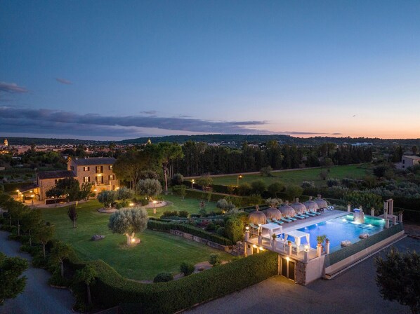Una extensa propiedad con piscina, jardines ajardinados y vistas del entorno.