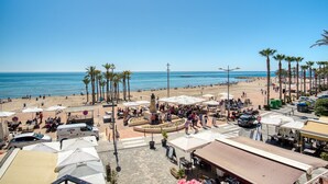 A beachside plaza with outdoor seating, palm trees, and a view of the ocean. - Apartamento 'Casa amarilla del mar piso 2' con vistas al mar, Wi-Fi y aire acondicionado (La Vila Joiosa)
