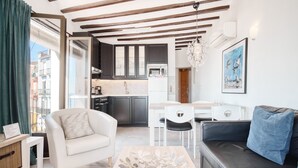 A modern living room with a sofa, a coffee table, and a dining area with chairs. - Apartamento 'Casa amarilla del mar piso 2' con vistas al mar, Wi-Fi y aire acondicionado (La Vila Joiosa)