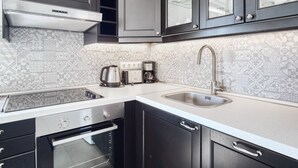 A modern kitchen with a stainless steel range hood, a double sink, and a built-in oven. - Apartamento 'Casa amarilla del mar piso 2' con vistas al mar, Wi-Fi y aire acondicionado (La Vila Joiosa)