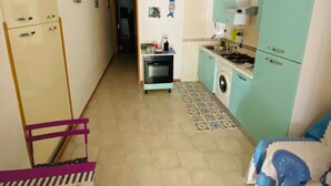 Kompakti asuintila, jossa on pieni keittiö, ruokailutila ja makuuhuone.