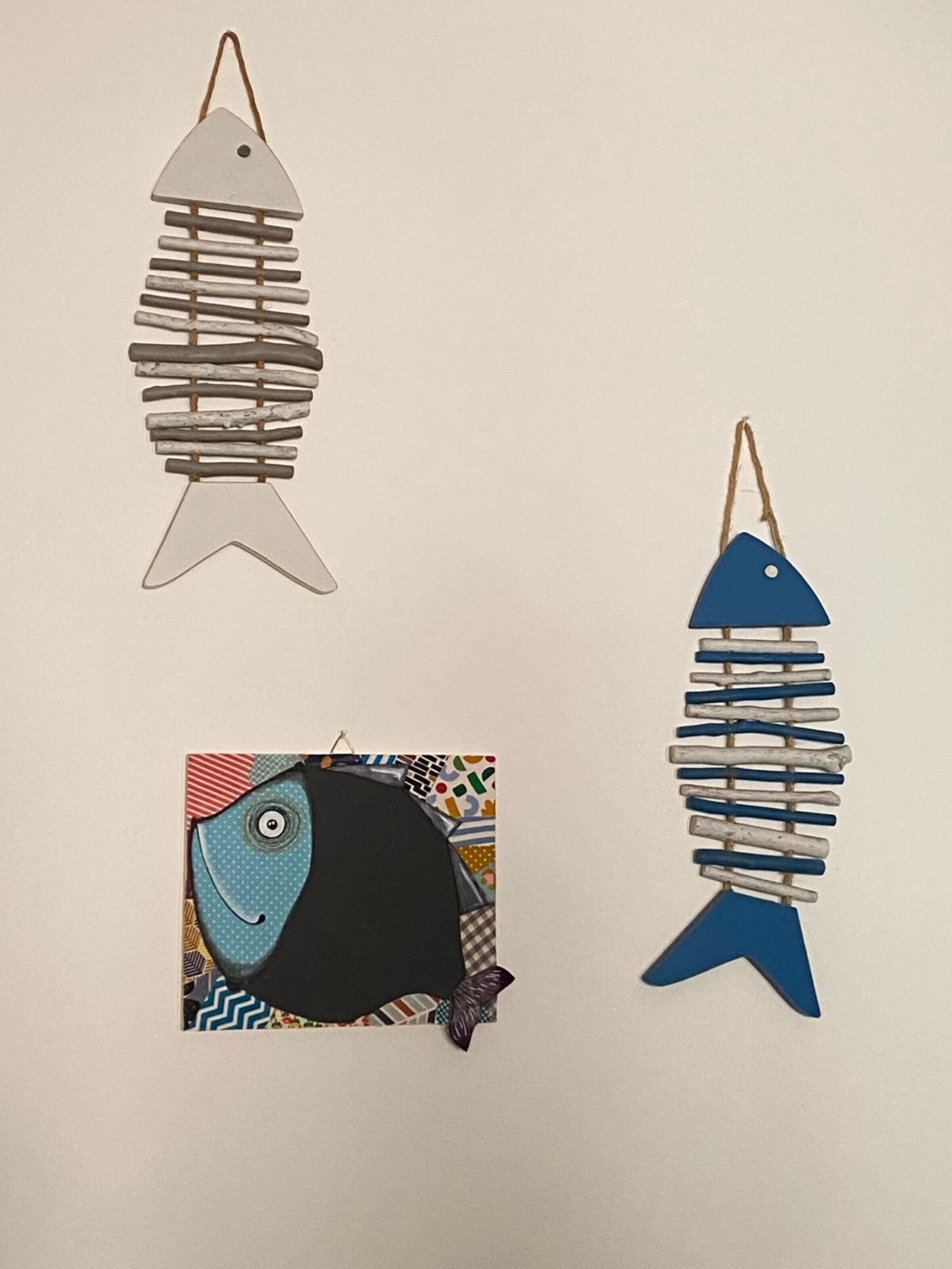Tres adornos con forma de pez, con distintos diseños y colores.
