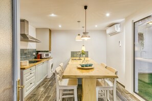 Une cuisine moderne dotée d’un îlot central, de meubles blancs et d’une grande fenêtre.