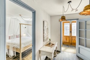Une chambre à coucher avec un lit, une table de chevet, une fenêtre et une porte.
