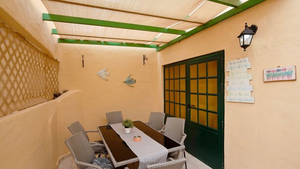 Un coin repas avec une table, des chaises et une porte verte.
