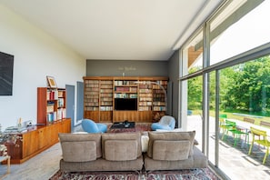 Un salon moderne avec une grande bibliothèque, un canapé et un téléviseur.