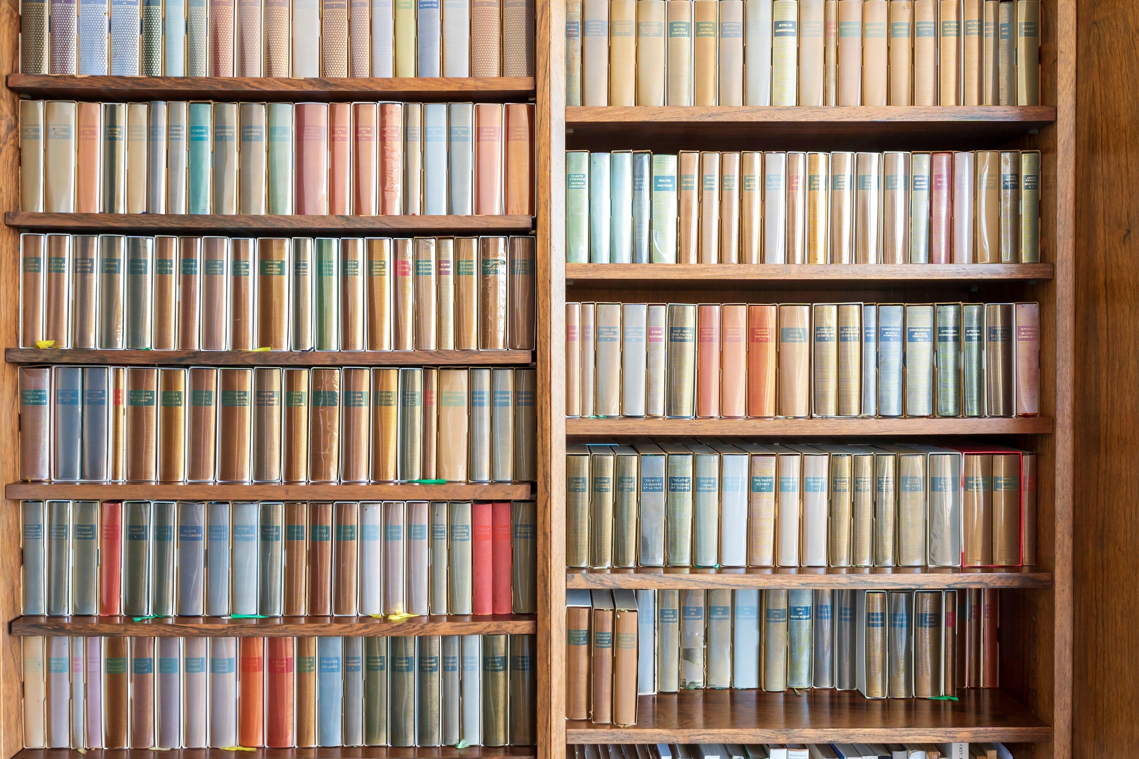 Una estantería con varios estantes llenos de libros.