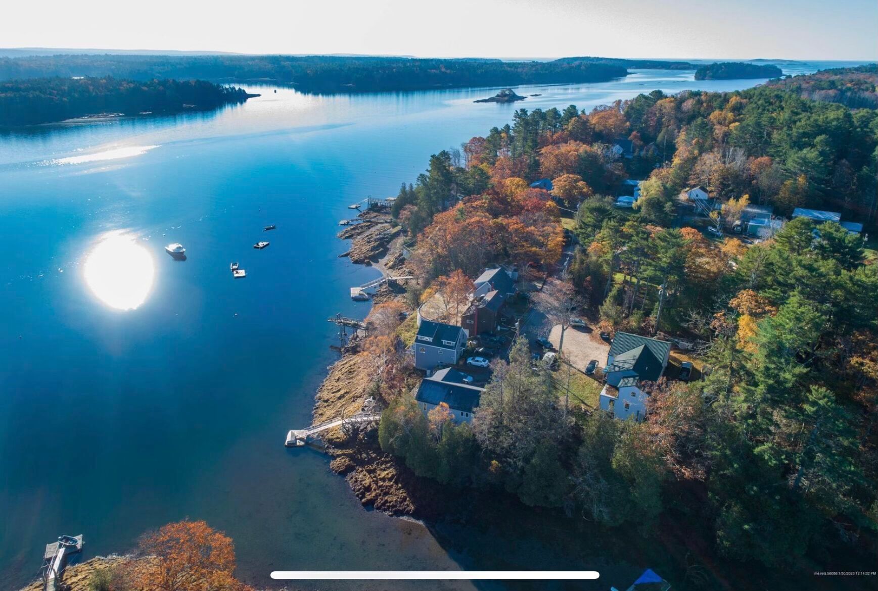 An aerial view of a lakeside community with houses, boats, and a dock.