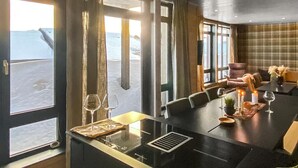 A dining area with a large table, chairs, and a view of the sea through large windows. - Amazing apartment in Noresund with WiFi (Noresund)