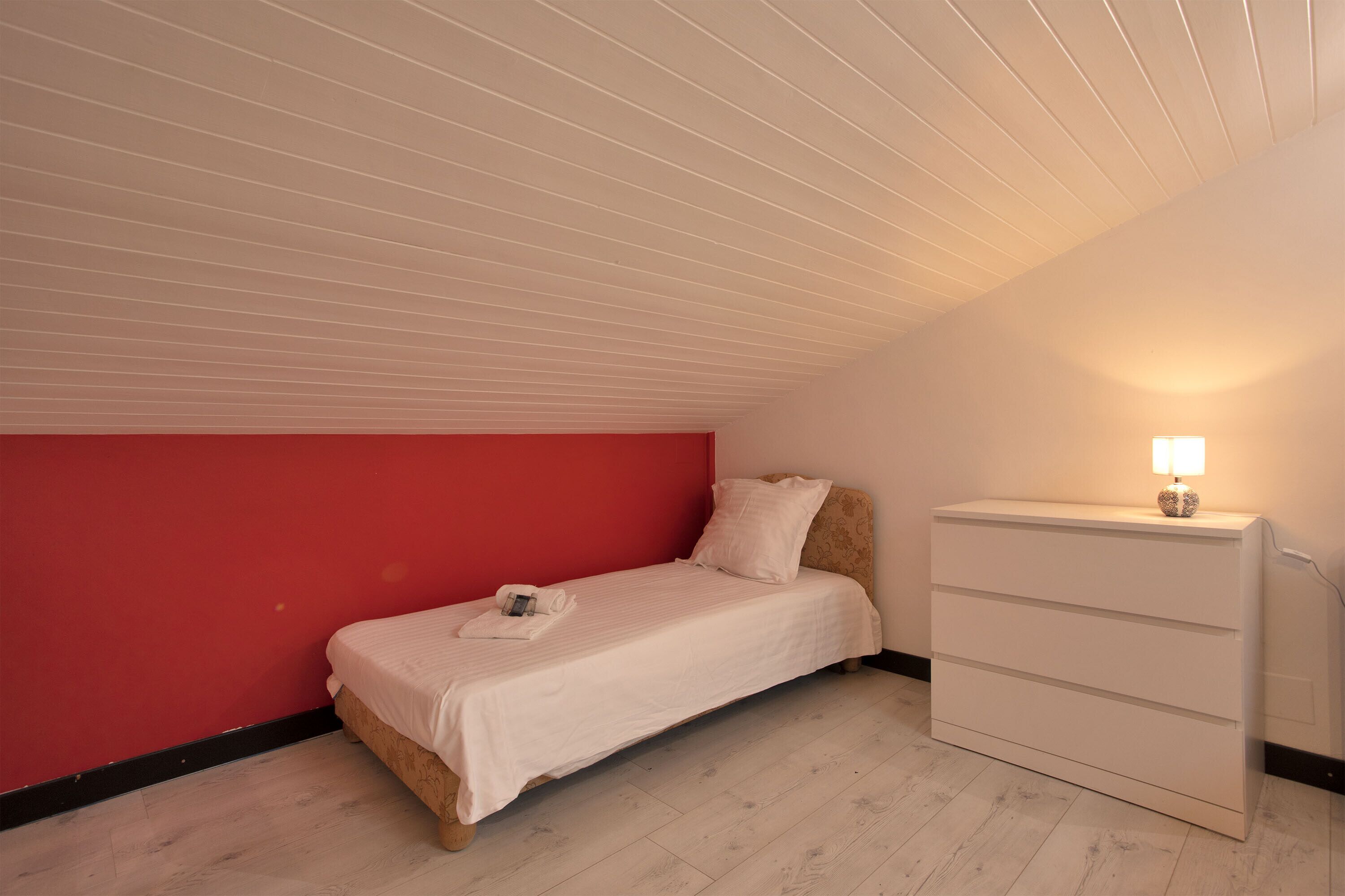 Ein Schlafzimmer mit einem Bett, einem Schminktisch und einem Nachttisch mit Lampe.