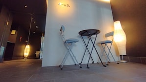 Un interior modern amb una taquilla d'admissió, dues cadires plegables i una làmpada penjada a la paret.
