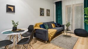 Una sala de estar moderna con un sofá, sillas, una mesita y una planta en maceta.