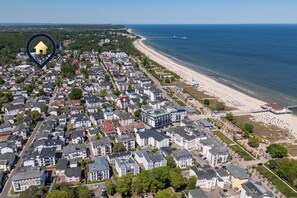 Ein Küstenwohngebiet mit Strand, Häusern und einem Steg.