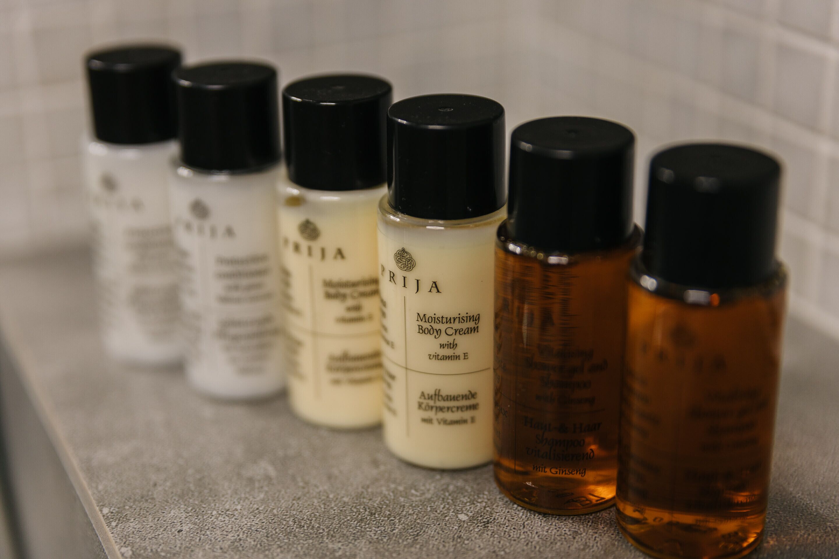 A row of skincare bottles on a textured surface.