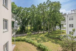 A residential area with multiple-story buildings, a grassy courtyard, and trees.