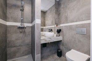 A modern bathroom with a shower, toilet, and sink.