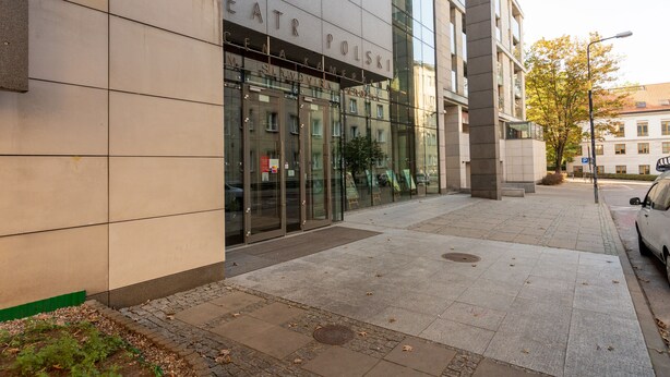 A modern building with a glass facade and a sign reading "EATR POLSKI". - Royal Route Apartment for 10 people (Warszawa)