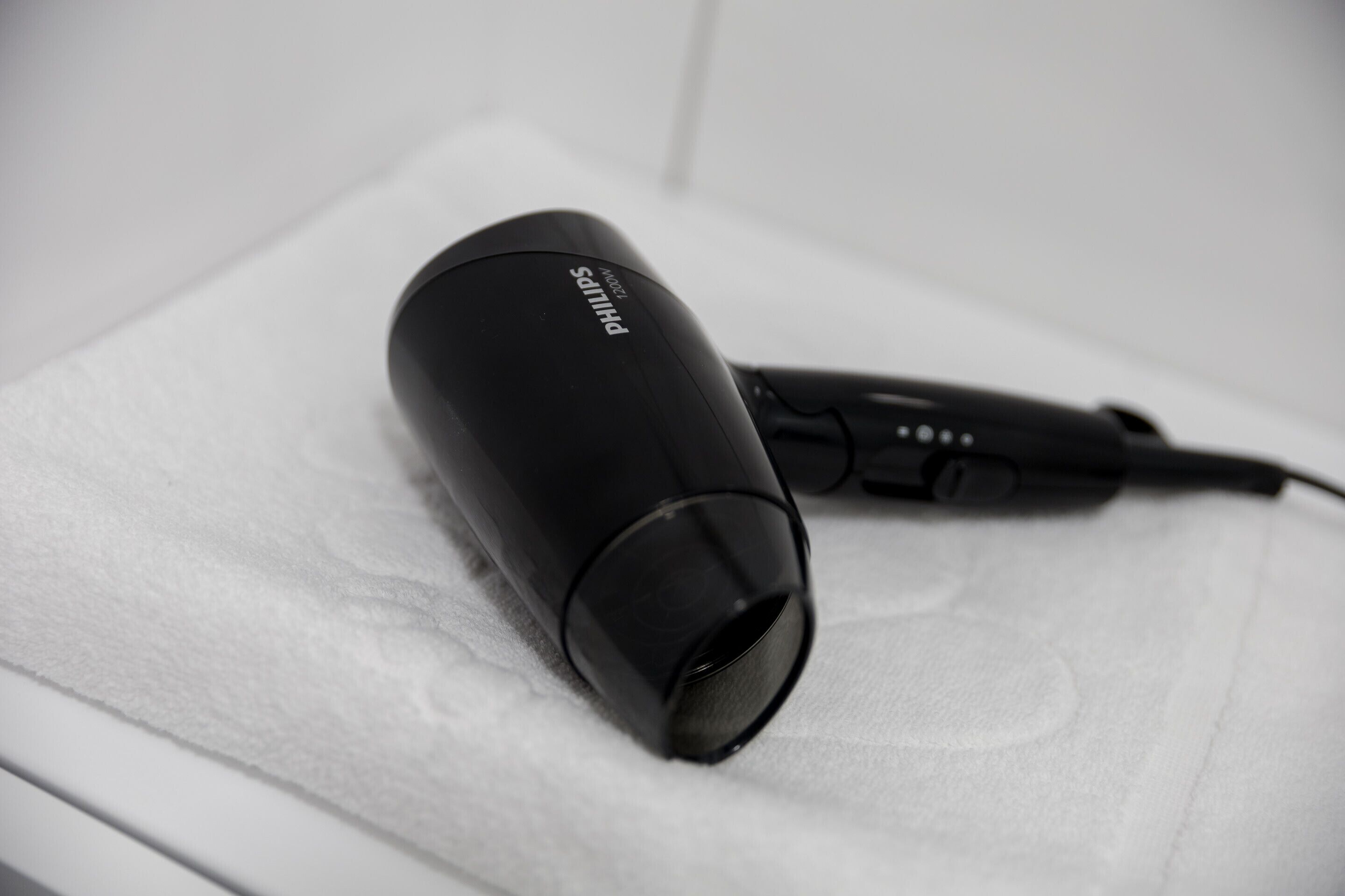 A black hair dryer on a white surface.