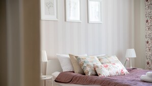 Une chambre à coucher bien rangée, avec un lit, des oreillers et des lampes de chevet.