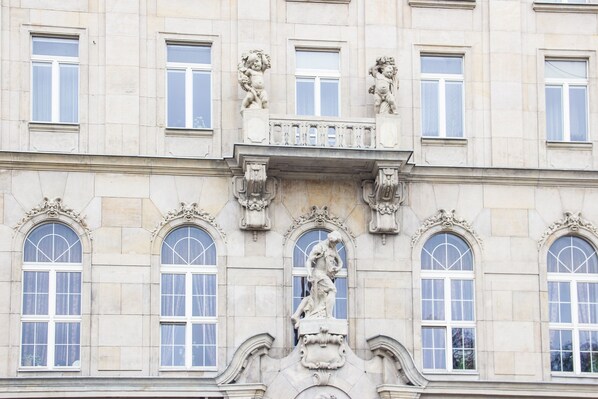 A building facade with arched windows and classical sculptures.
