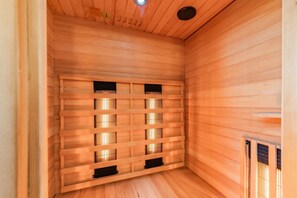 A sauna room with wooden walls and a slatted bench.