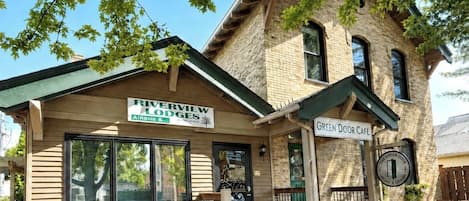 A brick building with a sign for Riverview Lodges and a Green Door Café.