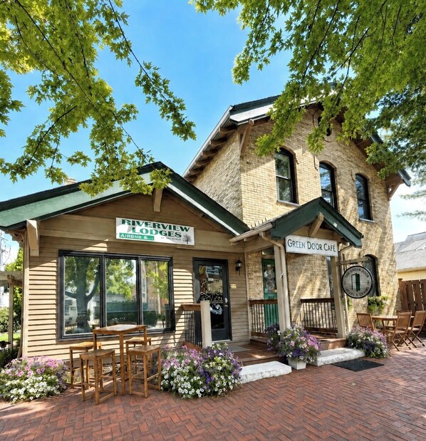 A brick building with a sign for Riverview Lodges and a Green Door Café. - Historic Downtown-Old World Charm-Dining-Coffee (Delafield)