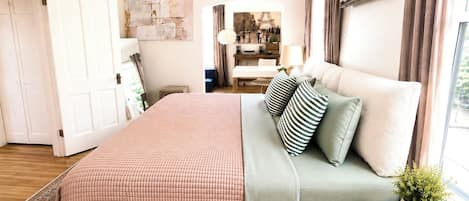 Un dormitorio con cama, mesita de noche y vista a un comedor.