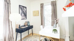 A modern room with a white desk, a black chair, a white lamp, and a chandelier. - Historic Downtown-Old World Charm-Dining-Coffee (Delafield)