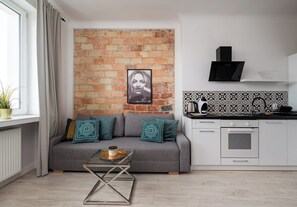 Una sala de estar moderna con un sofá gris, una mesa de centro y una pared de ladrillo.