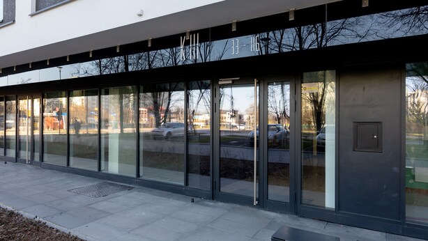 A modern building with large glass windows and a metal awning.