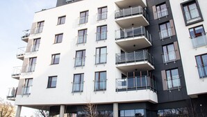 A multi-story building with balconies, large windows, and a modern architectural design.