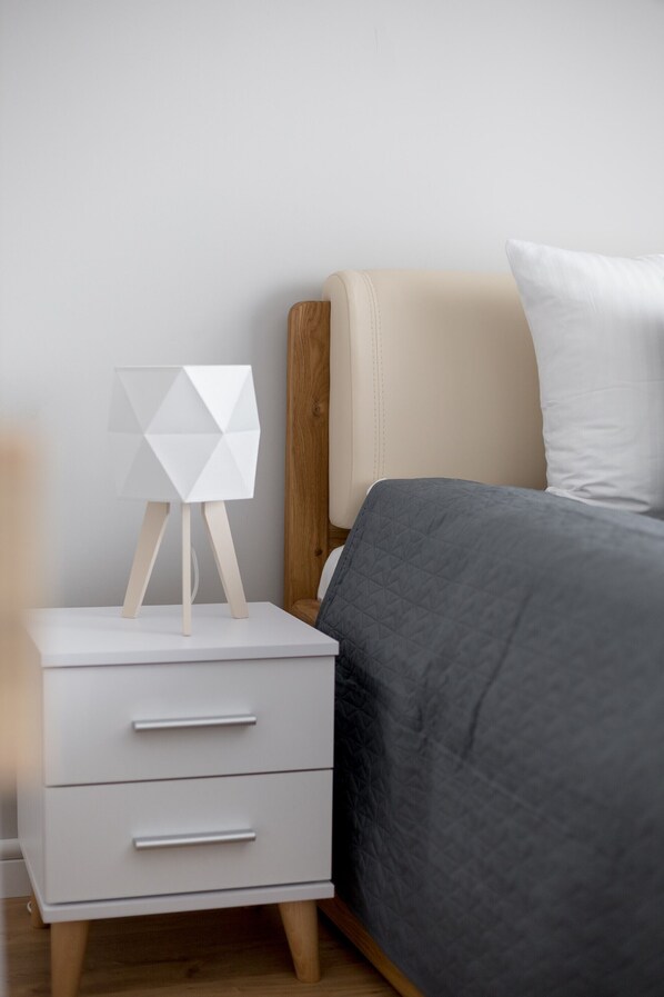 Une chambre à coucher avec un lit, une table de chevet avec une lampe et une commode.