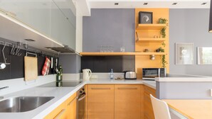 Een moderne keuken met houten kastjes, een roestvrijstalen spoelbak en een inbouwoven.
