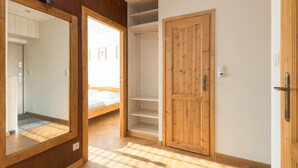 A bedroom with a wooden wardrobe, a bed, and a large mirror. - Piękna 2-Bedroom Apartment (Warszawa)