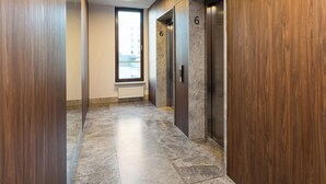 A modern elevator with a marble finish and a number 6 sign.