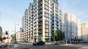 A multi-story hotel with balconies, a ground-level restaurant, and a pedestrian crossing.