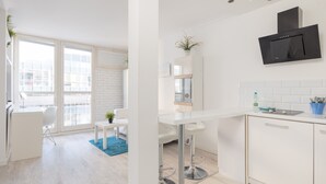 Una cocina moderna con armarios blancos, una campana extractora negra y una encimera azul.