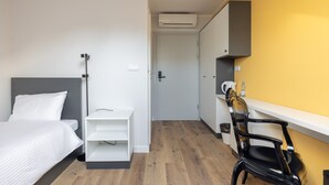 A hotel room with a bed, a desk, a chair, and a wardrobe. - ĄĘ Hostel  Nowy Świat (Warszawa)
