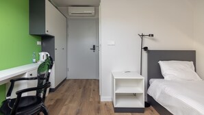 A compact room with a bed, a desk, and a chair. - ĄĘ Hostel Nowy Świat (Warszawa)
