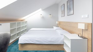 A modern bedroom with a skylight, a bed, a nightstand, and a built-in wardrobe.