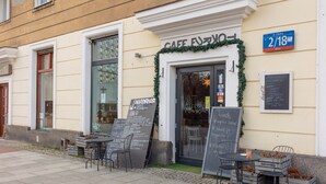 Ein Café mit Außenplätzen, einer Kreidetafel und einem Preisschild.