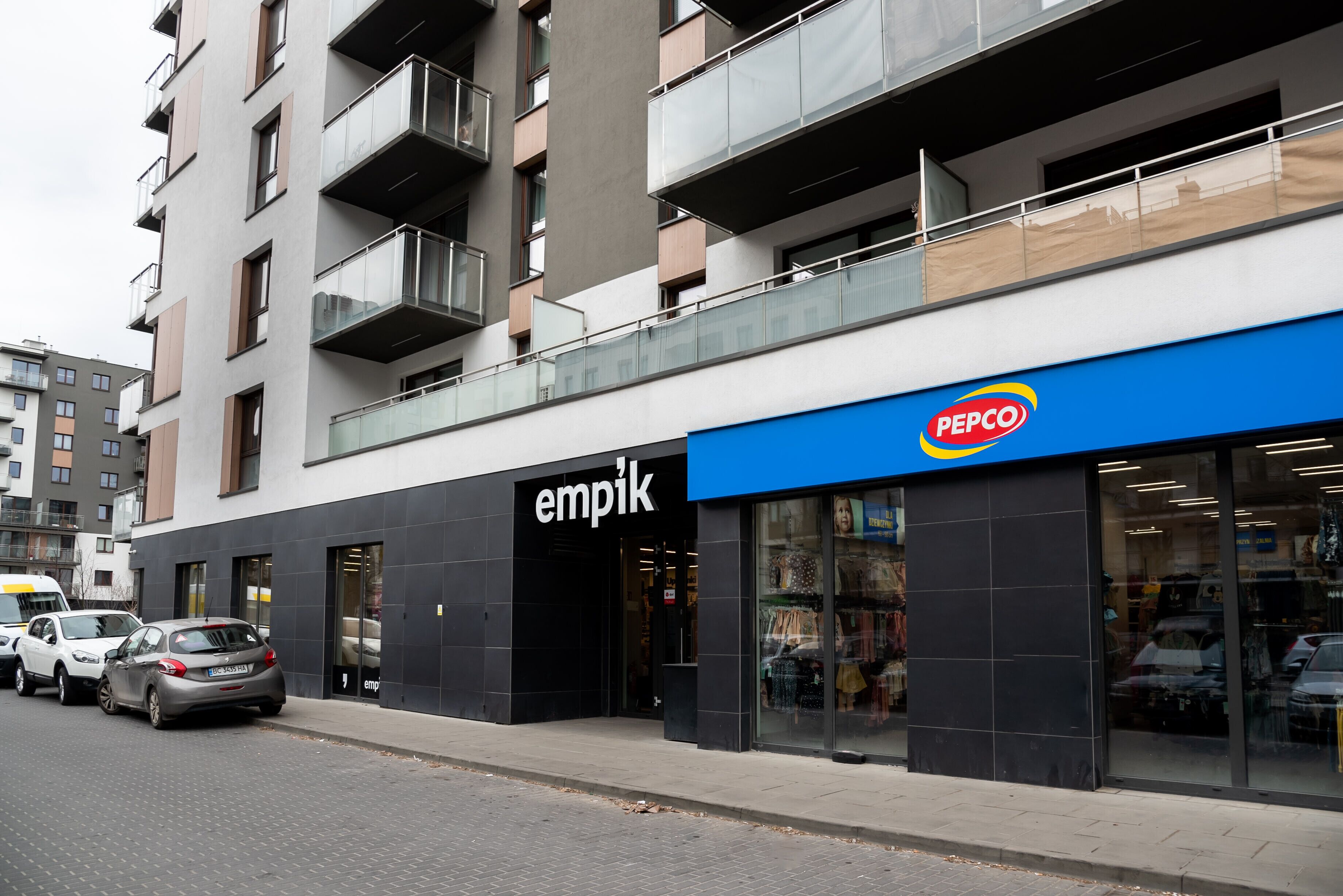 Ein modernes Gebäude mit einem Geschäft namens 'empik' und einem 'PEPCO'-Schild.