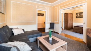 A modern living room with a sectional sofa, a coffee table, and a view into the kitchen. - City Centre Open View Apartment (Warszawa)