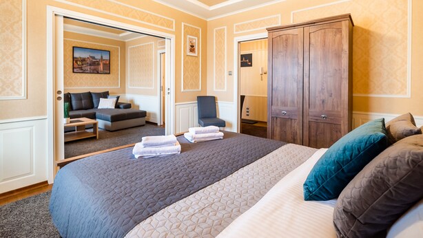 A hotel room with a large bed, a wardrobe, a sofa, and a chair. - City Centre Open View Apartment (Warszawa)
