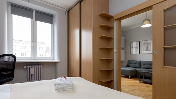 Ein Hotelzimmer mit einem Bett, einem Sessel, einem Heizkörper, einem Fenster und Blick nach draußen.