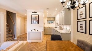 A modern kitchen with white cabinets, a marble countertop, and a built-in oven. - Lovely Apartment In The Heart of Warsaw (Warszawa)